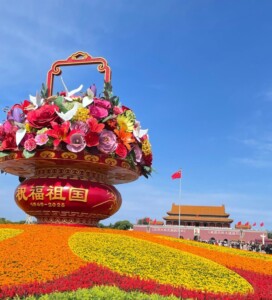 国慶節に飾られる巨大な花籠オブジェと色鮮やかな花畑。背景には天安門が見える。