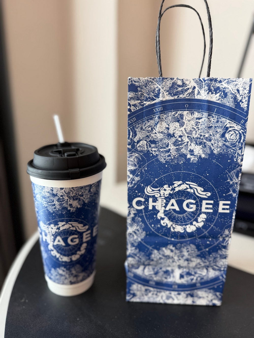 テーブルに並べたCHAGEEの青と白の柄のドリンクカップと持ち帰り用の紙袋
